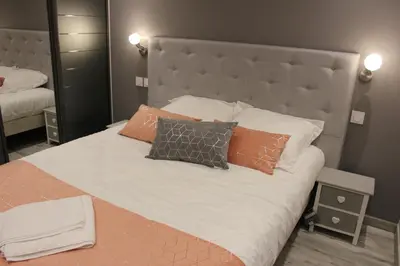 a bed with orange and white pillows on it at Appartement 3 pièces Nice Promenade des anglais dernier étage vue mer solarium in Nice