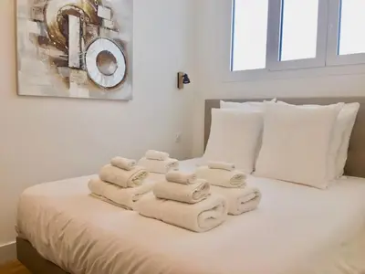 a bed with towels stacked on top of it at Florida Blue - Easy Home Booking in Nice