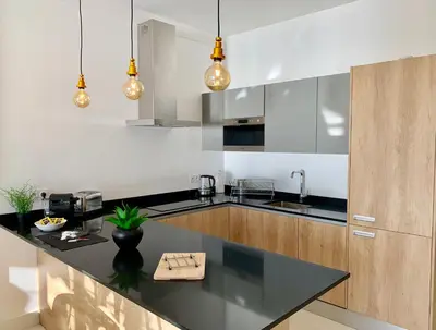 a kitchen with a black counter top and wooden cabinets at Florida Blue - Easy Home Booking in Nice