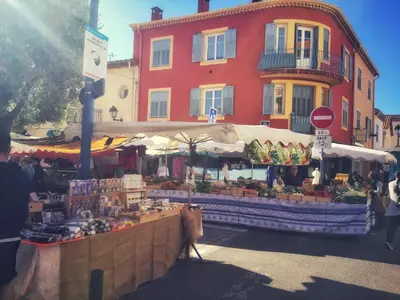 a market in front of a red building at Villa du Cros in Cagnes-sur-Mer