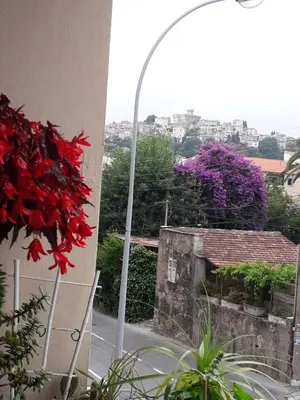 a street light next to a building with purple flowers at Chambre chez l’habitant chez Nadine in Cagnes-sur-Mer