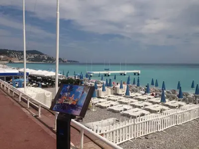 a beach with chairs and umbrellas and the ocean at Stylish 2 Room Flat 60 meters to the beach in Nice