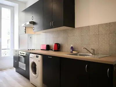 a kitchen with a sink and a washing machine at Appartement Urban 3 in Nice