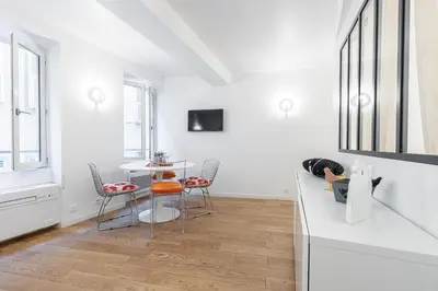 a white room with a table and chairs and a table at Quiet and cosy 1bdr in Vieux Nice! in Nice
