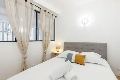 a bedroom with a white bed and a window at Quiet and cosy 1bdr in Vieux Nice! in Nice