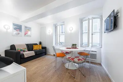 a living room with a couch and a table and chairs at Quiet and cosy 1bdr in Vieux Nice! in Nice