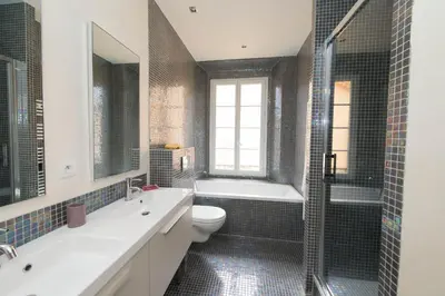 a bathroom with a tub and a toilet and a sink at La Garibaldi in Nice