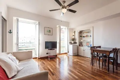 a living room with a ceiling fan and a table at Irene Apartment in Nice