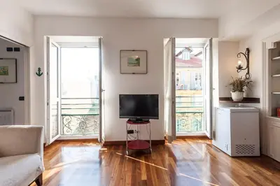 a living room with a television and two large windows at Irene Apartment in Nice