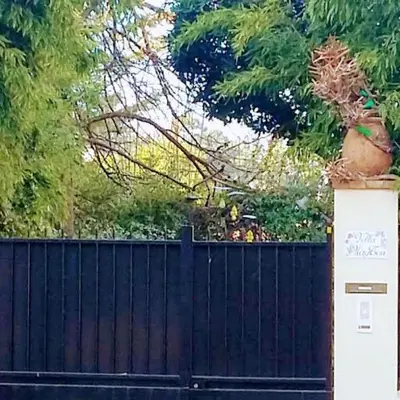 a black fence with a tree behind it at Appartement Nice Port in Nice