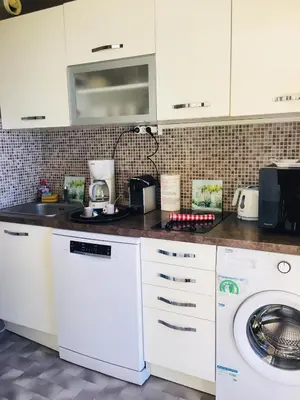 a kitchen with a washing machine and a microwave at Oasis Méditerranéen Piscine & Parking Calme absolu in Nice