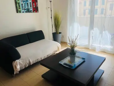 a living room with a couch and a coffee table at Le Californie Côte d'azur plage les pieds dans L'eau in Nice