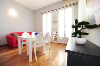 a living room with a white table and a red couch at Suite Halevy 5 stars Holiday House in Nice