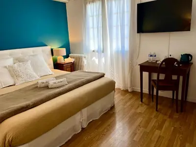 a bedroom with a bed with a desk and a television at Villa Antoline in Cagnes-sur-Mer