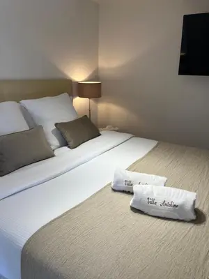 a large white bed with two white pillows on it at Villa Antoline in Cagnes-sur-Mer