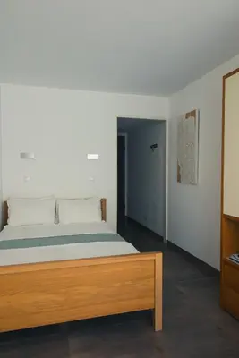 a bedroom with a large bed with a wooden frame at Les Jasmins in Beaulieu-sur-Mer