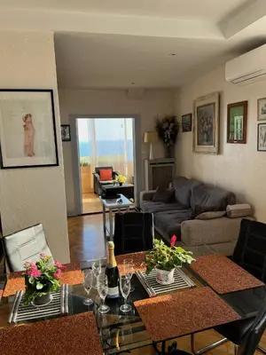 a living room with a table and a couch at France Nice Promenade Des Anglais 80m² Piano in Nice