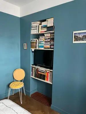 a room with a blue wall with a tv and a chair at France Nice Promenade Des Anglais 80m² Piano in Nice