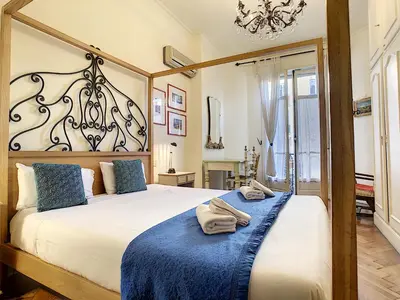 a bedroom with a large bed with a blue blanket at Nestor&Jeeves - SIXTIES - Central - Very close sea - Retro in Nice