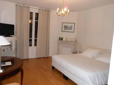 a white bedroom with a bed and a table at Hotel Villa Les Cygnes in Nice
