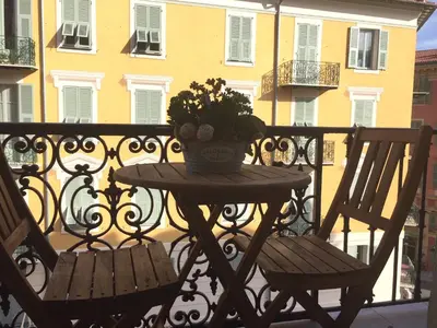 a table with a vase of flowers on a balcony at Port de Nice in Nice