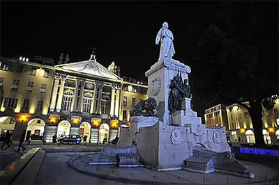 a statue in front of a building at night at Port de Nice in Nice