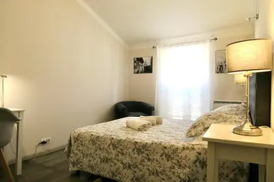 a bedroom with a bed with a lamp and a chair at Promenade sur les toits in Nice