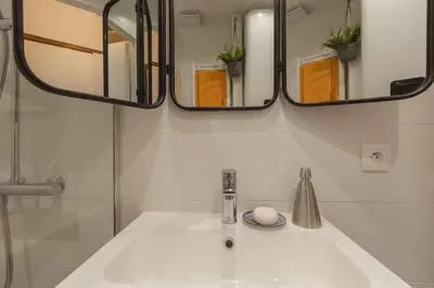 a bathroom with a sink and two mirrors at Nicelidays - Le Berlioz - city central - 7min from beaches in Nice