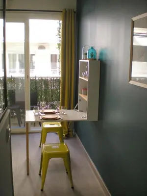 a dining room with a table and two yellow chairs at Nicelidays - Le Berlioz - city central - 7min from beaches in Nice