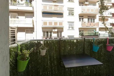 a balcony with potted plants in front of a building at Nicelidays - Le Berlioz - city central - 7min from beaches in Nice