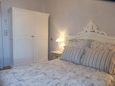 a bedroom with a white bed with a white cabinet at Hotel La Regence in Villefranche-sur-Mer