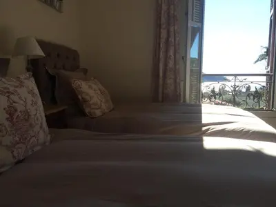 a bedroom with a bed and a window with a view at Hotel La Regence in Villefranche-sur-Mer