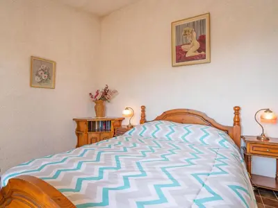 a bedroom with a bed and two night stands and two tables at Holiday Home La Mesnière by Interhome in Gattières