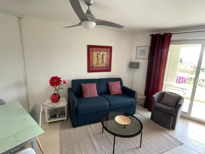 a living room with a blue couch and a table at Renoir Appartement in Cagnes-sur-Mer