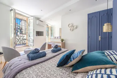 a bedroom with a large bed with blue pillows at Place Du Pin in Nice