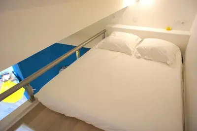 a bed with white pillows in a room at Ze Perfect Place - Superbe Studio Vieux Nice - calme et climatisé in Nice