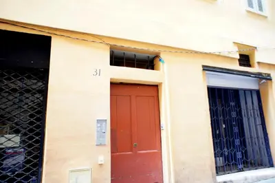 a building with a red door and two windows at Ze Perfect Place - Superbe Studio Vieux Nice - calme et climatisé in Nice