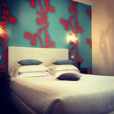 a bedroom with a large bed with red dragons on the wall at Hotel Villa Rose in Nice