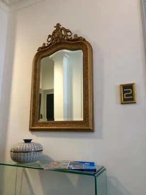 a mirror on a wall next to a glass table at Hotel Villa Rose in Nice