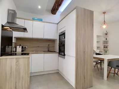 a kitchen with white cabinets and a table with chairs at Nestor&Jeeves - HOUSE OF CARDS - Central - Very close sea in Nice