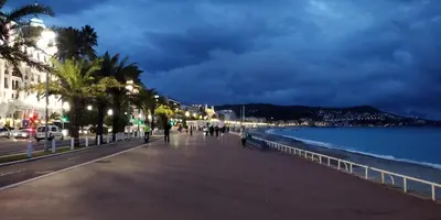 a city street with palm trees and the ocean at night at Nice Seaview Free Parking 4.Pers in Nice