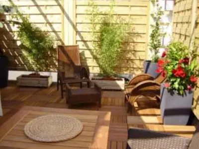 a screened in porch with a chair and plants at Intérieurs-Cour in Nice