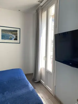 a bedroom with a flat screen tv and a window at Intérieurs-Cour in Nice
