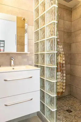 a bathroom with a sink and a glass wall at Place du Pin in Nice