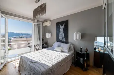 a bedroom with a large bed and a large window at Villa Iris in Nice
