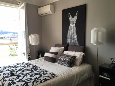 a bedroom with a bed with a dress hanging on the wall at Villa Iris in Nice