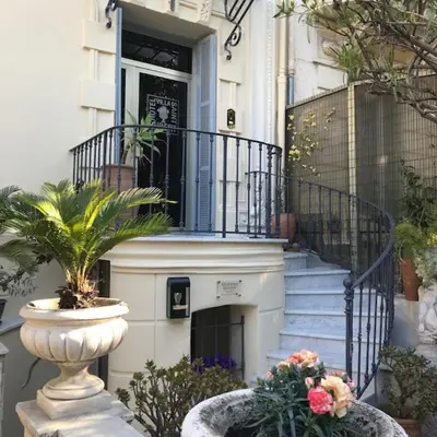 a house with a staircase and a vase with flowers at Villa Saint Hubert in Nice