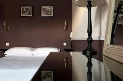 a bedroom with a bed and a table with a lamp at Villa Saint Hubert in Nice