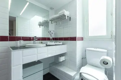 a white bathroom with a toilet and a sink at Nice Appart in Nice