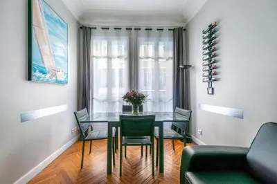 a dining room with a glass table and chairs at Nice Central Art Deco Flat 45 m² in Nice
